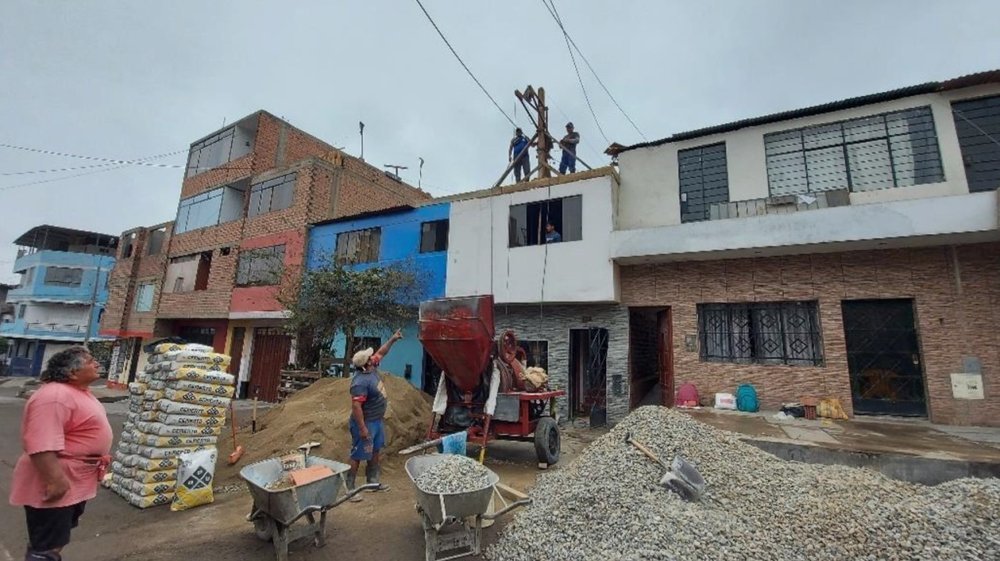 Trabajadores de construcción levantando un segundo piso en una vivienda de autoconstrucción progresiva en Lima