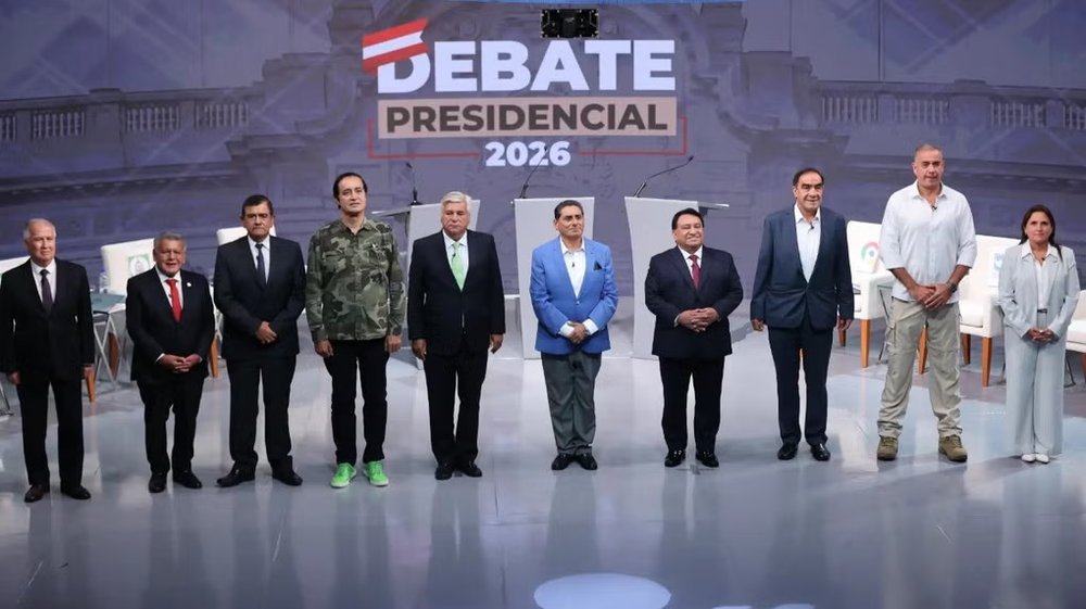 Los siete candidatos presidenciales de pie en el escenario del Debate Presidencial 2026 organizado por el JNE