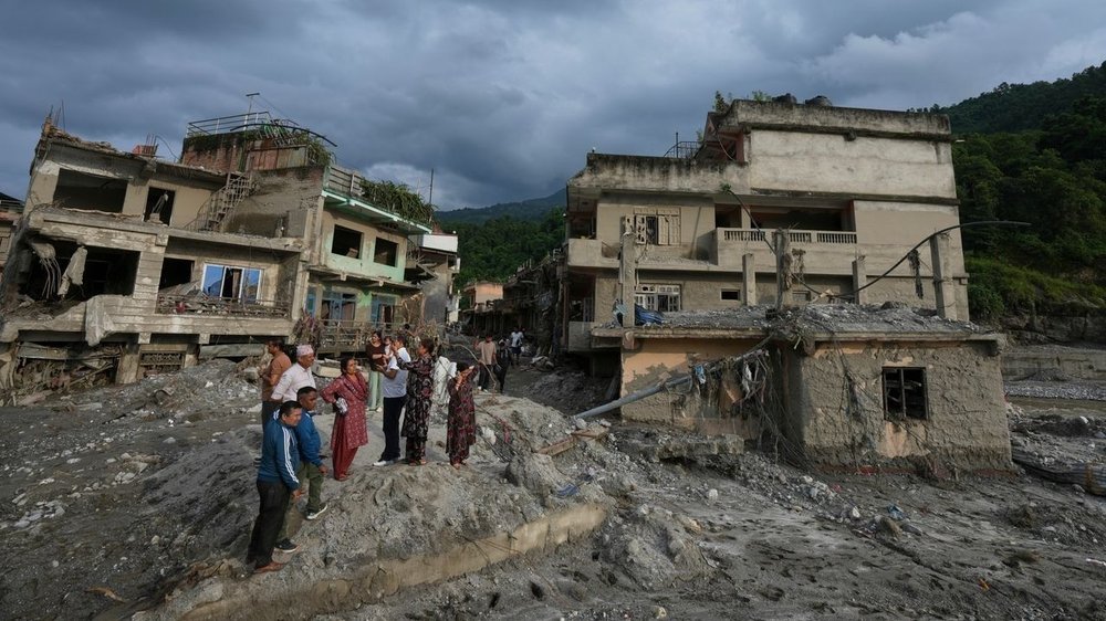 Residentes observando edificios destruidos por una inundación repentina en Devighat, Nepal, en 2026